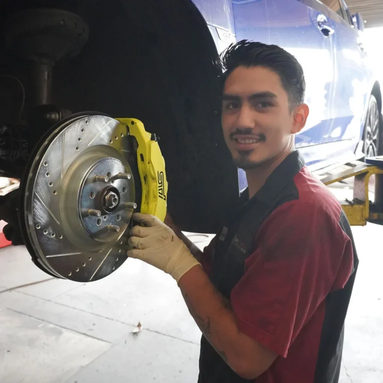 Technician performing a brake repair on a STI