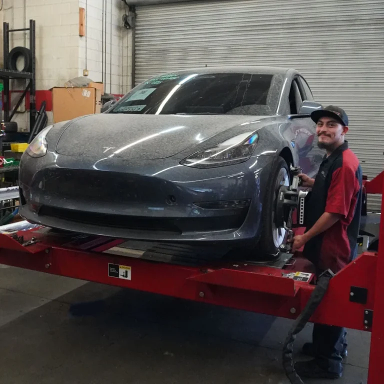 Mechanic Performing A Wheel Alignment On A Tesla Model 3